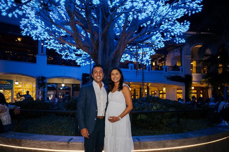 Couple standing n front of blue LED tree 